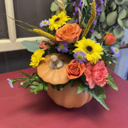 Pumpkin-shaped floral arrangement with orange roses and yellow daisies