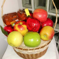 Fruit basket with apples and wrapped candies in a wicker basket