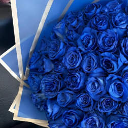Bouquet of vivid blue roses wrapped in blue paper