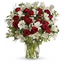 Bouquet of red roses and white alstroemeria in a clear glass vase