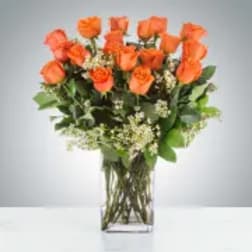 Orange roses arranged in a clear glass vase