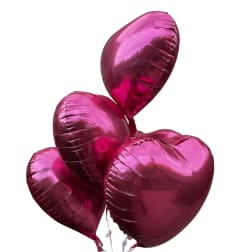 Cluster of metallic pink heart-shaped balloons on a white background