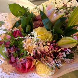 Mixed bouquet of roses and lilies in pastel wrapping