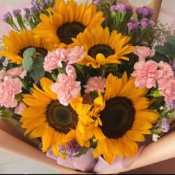 Bouquet of sunflowers and pink carnations with purple filler flowers