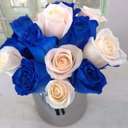 Blue and white roses arranged in a clear vase
