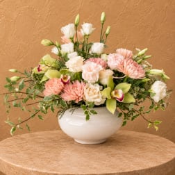 Mixed pastel flower arrangement in a white bowl vase