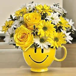Yellow smiley-face mug filled with yellow and white flowers