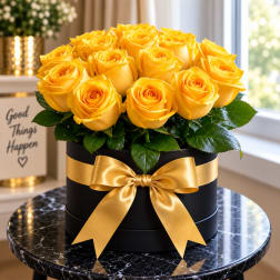 Yellow roses arranged in a black round box with a gold ribbon