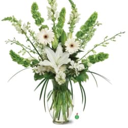 White lilies and daisies in a clear glass vase with tall green spikes