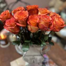 Orange roses arranged in a decorative vase