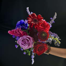 Handheld bouquet with red, lavender, and blue flowers