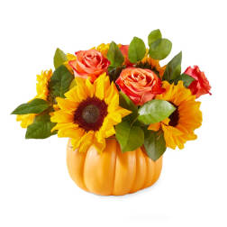Sunflowers and orange roses arranged in a pumpkin-shaped container