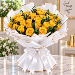 Bouquet of yellow roses wrapped in white paper with gold trim and a white ribbon