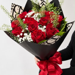 Bouquet of red roses with white baby's breath in black wrap and a red ribbon