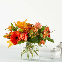 Orange and peach mixed bouquet in a clear glass vase