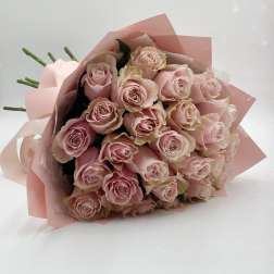 Bouquet of pale pink roses wrapped in pink paper