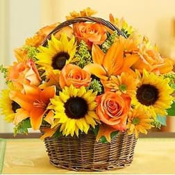 Basket of orange roses, sunflowers, and lilies