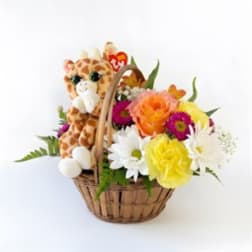Basket of mixed flowers with a plush giraffe toy