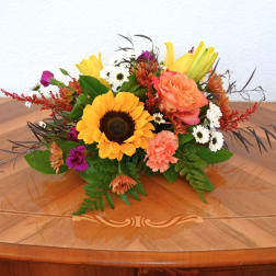 Mixed bouquet with a sunflower, peach roses, and small white daisies