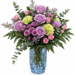 Lavender and pink roses with purple mums in a blue glass vase