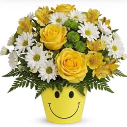 Yellow roses and white daisies in a smiley-face pot