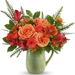 Orange roses and red alstroemeria in a green ceramic pitcher