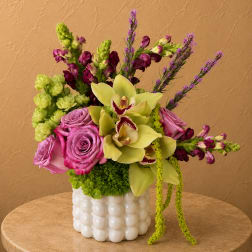 Pink roses and green orchids in a white textured vase