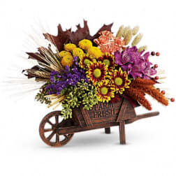 Fall flower arrangement in a wooden wheelbarrow container