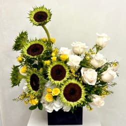Sunflowers and white roses arranged in a black box