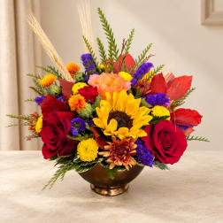 Mixed bouquet with sunflowers, red roses, and colorful mums in a bronze bowl vase