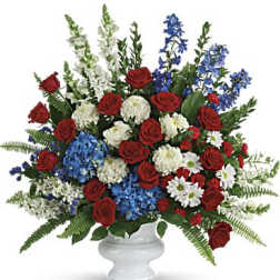 Red roses, blue and white flowers in a white vase