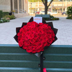 Large bouquet of red roses wrapped in black paper