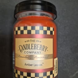 Amber jar candle with a black lid and labeled front