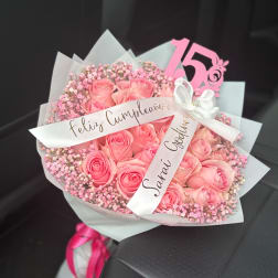 Pink rose bouquet with baby’s breath and a white ribbon