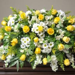 Yellow roses and white daisies arranged on a casket