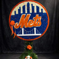 New York Mets floral sign with orange ribbon accents on a stand