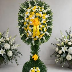 Tall standing floral wreath with yellow and white flowers and yellow ribbon
