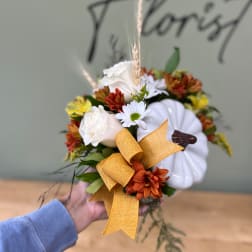 Handheld floral arrangement with white pumpkins, daisies, and orange blooms