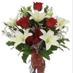 Bouquet of red roses and white lilies in a glass vase