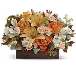 Orange roses and lilies arranged in a wooden box
