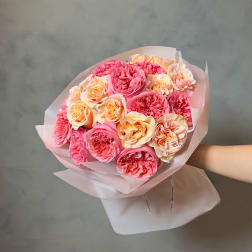 Bouquet of pink and peach roses wrapped in pale paper