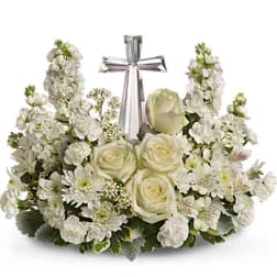 White floral sympathy arrangement with a silver cross centerpiece
