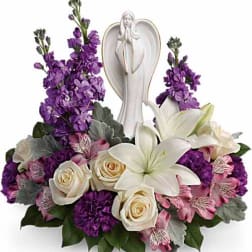 White angel figurine surrounded by purple and white flowers
