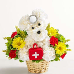 White teddy bear floral arrangement in a basket with a red first-aid bag