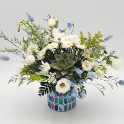 White and blue mixed bouquet in a mosaic ceramic pot with a succulent center