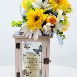 Yellow and white floral arrangement on a memorial lantern