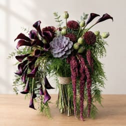 Bouquet with dark calla lilies, burgundy blooms, and a succulent centerpiece