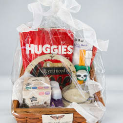 Gift basket with baby items wrapped in clear cellophane and a white bow