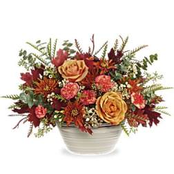 Autumn floral arrangement in a white ceramic bowl with yellow roses and red blooms
