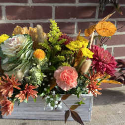 Autumn floral arrangement in a white wooden box with chrysanthemums and carnations